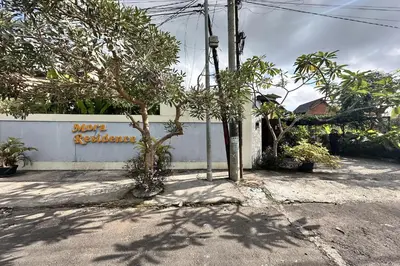 a wall with a tree in front of a building at Mora Residence Jimbaran in Jimbaran