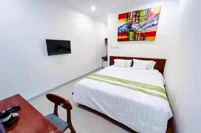 a bedroom with a bed and a table and a tv at Mora Residence Jimbaran in Jimbaran