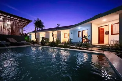 a swimming pool in front of a house at night at Mora Residence Jimbaran in Jimbaran