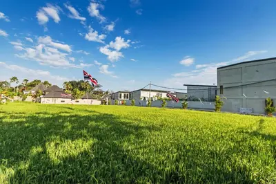 a field of green grass with two american flags at Manresa Villa Bali 3 in Canggu
