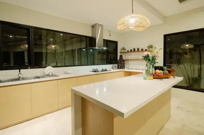 a large kitchen with a large white counter top at Maribel Villa Bali in Seminyak