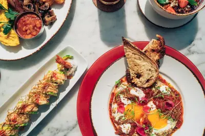 a table topped with plates of food with toast at Morabito Art Villa in Canggu