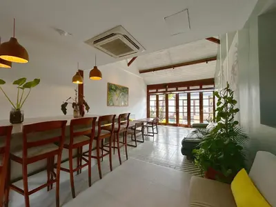 a dining room with a bar with stools at Batu Belig Living by CPM Bali in Seminyak