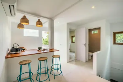 a kitchen with two bar stools and a counter at Batu Belig Living by CPM Bali in Seminyak
