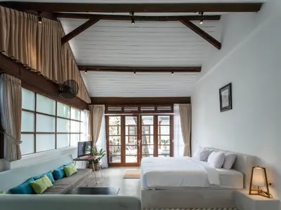 a bedroom with a large bed and a couch at Batu Belig Living by CPM Bali in Seminyak