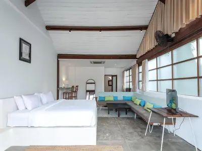 a bedroom with a large bed and a couch at Batu Belig Living by CPM Bali in Seminyak