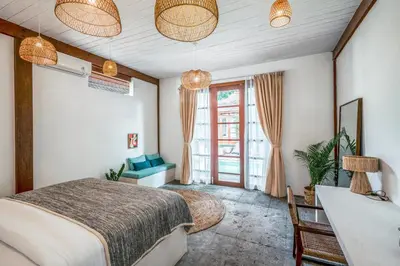 a bedroom with a bed and a desk and a window at Batu Belig Living by CPM Bali in Seminyak