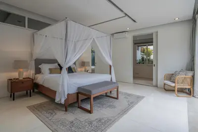 a bedroom with a bed with a canopy at Villa Batu Sari in Canggu