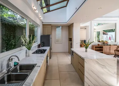 a kitchen with marble counter tops and a large window at Villa Batu Sari in Canggu