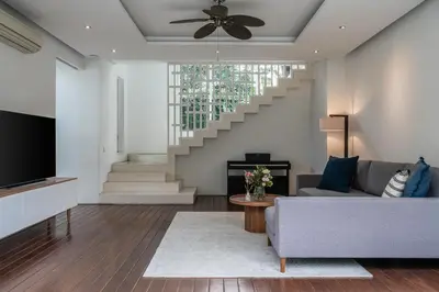 a living room with a couch and a staircase at Villa Batu Sari in Canggu