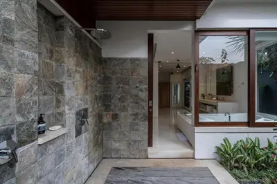 a bathroom with a tub and a sink and a mirror at Villa Batu Sari in Canggu