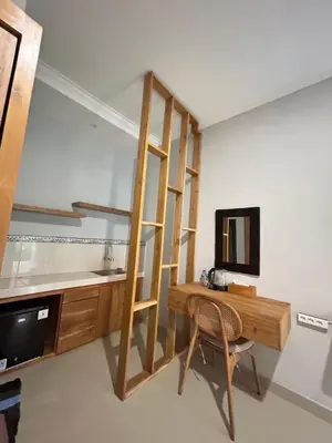a room with a wooden desk and a mirror at Pondok Puspa Sumekar in Seminyak