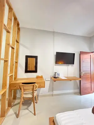 a bedroom with a desk and a tv on a wall at Pondok Puspa Sumekar in Seminyak