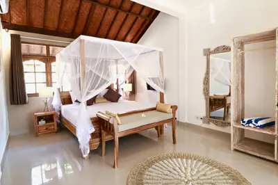 a bedroom with a canopy bed and a mirror at Villa Santai, huge garden Seminyak square in Seminyak