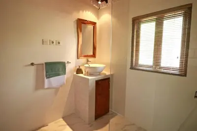 a bathroom with a sink and a mirror at Villa Santai, huge garden Seminyak square in Seminyak