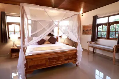 a bedroom with a canopy bed with mosquito nets at Villa Santai, huge garden Seminyak square in Seminyak