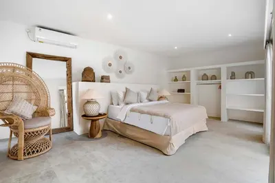 a bedroom with a bed and a mirror and a chair at A Casa Di Renucci by Alfred in Bali in Seminyak