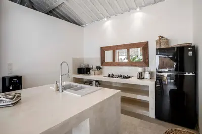 a kitchen with a sink and a black refrigerator at A Casa Di Renucci by Alfred in Bali in Seminyak
