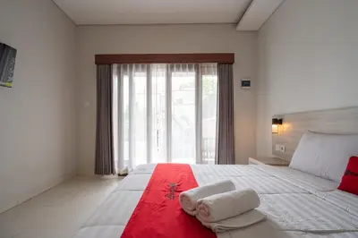 a bedroom with a large bed with towels on it at RedDoorz Plus at Yasa's Living Denpasar in Sanur