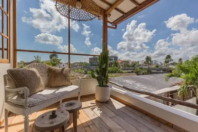 a balcony with a couch and a view of the city at 7BR Villa Private Pool Yoga Gym Cinema 10min Canggu Surfing Beach in Kerobokan