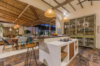 an open kitchen and dining room with a table and chairs at 7BR Villa Private Pool Yoga Gym Cinema 10min Canggu Surfing Beach in Kerobokan