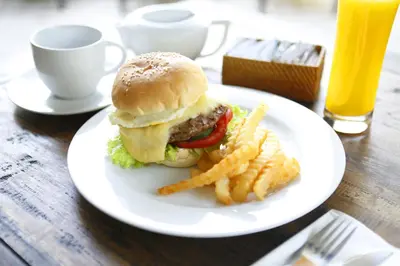 a plate with a hamburger and french fries on a table at 7 Bidadari Hotel Seminyak in Seminyak