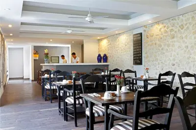 a restaurant with tables and chairs and a counter at 7 Bidadari Hotel Seminyak in Seminyak