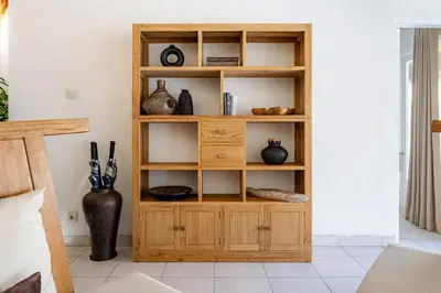 a wooden book shelf in a room with vases at Newly renovated Villa Noa by Optimum Bali Villas in Seminyak