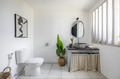 a white bathroom with a toilet and a mirror at Newly renovated Villa Noa by Optimum Bali Villas in Seminyak