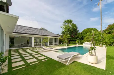 a backyard with a swimming pool and a house at Villa Vulla in Seminyak