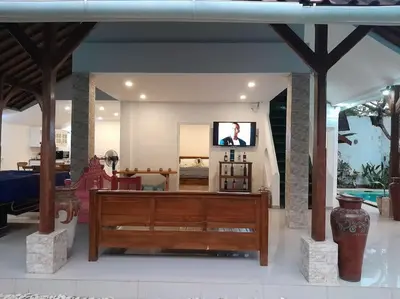 a living room with a tv and a wooden couch at 2BR private villa in Seminyak, Ayu Putri in Seminyak