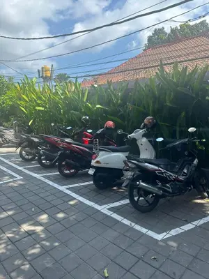 a row of motorcycles parked in a parking lot at Pudak Sari Homestay in Kuta