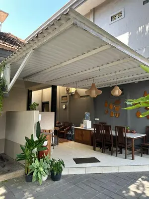 an outdoor patio with a table and chairs at Pudak Sari Homestay in Kuta