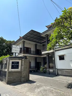 a house with a sign in front of it at Pudak Sari Homestay in Kuta