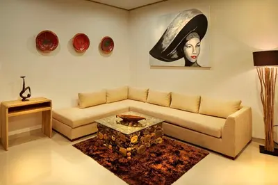 a living room with a couch and a painting of a woman at Sol Bella VIlla 1 in Seminyak