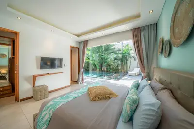 a bedroom with a large bed and a large window at Villa Cuatro : Amazing 3BR Villa in Seminyak - Perfect Location in Seminyak