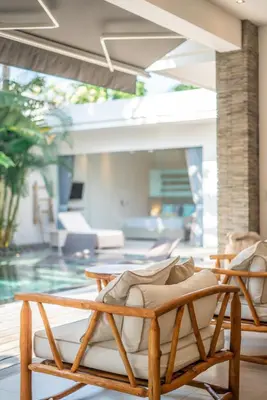 a patio with two lounge chairs and a pool at Villa Cuatro : Amazing 3BR Villa in Seminyak - Perfect Location in Seminyak