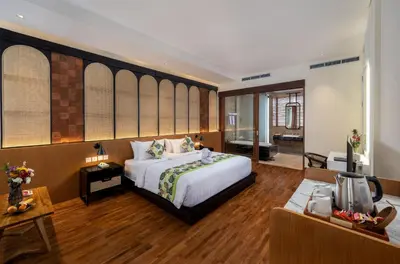 a bedroom with a large bed and a living room at Mokko Suites Batubelig in Canggu