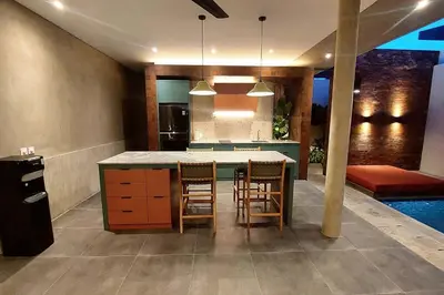 a kitchen with a table and chairs and a pool at Villa Akhila 2 - 2 BR modern tropical villa at the heart of Seminyak in Seminyak