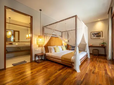 a bedroom with a bed with a canopy at Bumbak Park Villas By Nakula in Canggu
