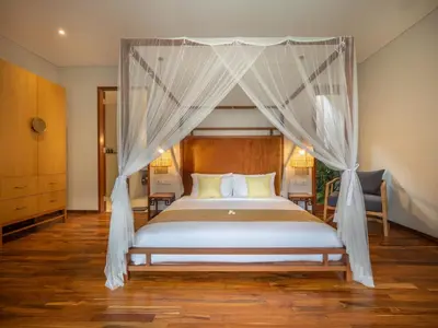a bedroom with a bed with a canopy at Bumbak Park Villas By Nakula in Canggu