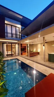 a large house with a swimming pool in front of it at Akhila 3 - 2 BR Modern tropical villa at the heart of Seminyak in Seminyak