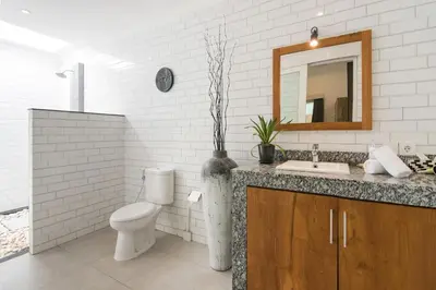 a bathroom with a toilet and a sink and a mirror at Modern villa near Atlas beach club & beach in Canggu