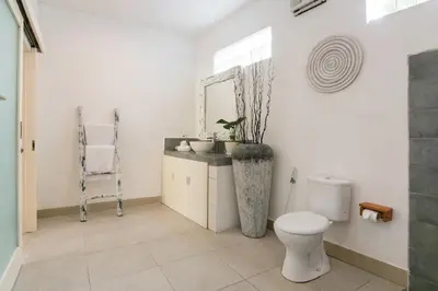 a bathroom with a toilet and a sink and a mirror at Incredible villa near Atlas beach club Berawa in Canggu