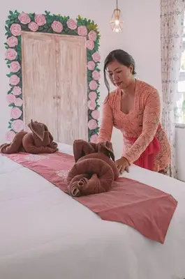 a woman standing on a bed with two teddy bears at Bohemian Kasya Villa Bali in Seminyak