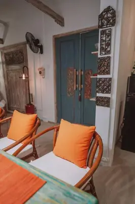 a room with two chairs and a table and a blue door at Bohemian Kasya Villa Bali in Seminyak