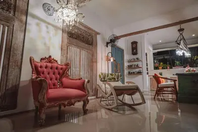 a living room with a red chair and a chandelier at Bohemian Kasya Villa Bali in Seminyak