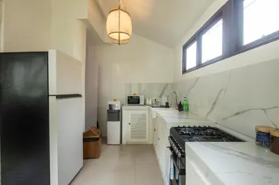 a kitchen with a black refrigerator and white counter tops at Monroe 3BR Luxury Villa Seminyak BREAKFAST INCL Netflix Private Pool 900m to Beach in Seminyak