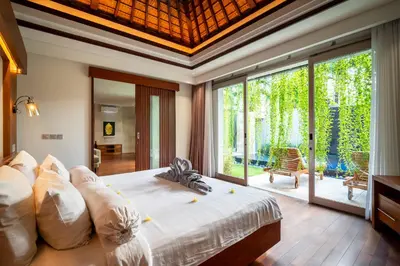 a bedroom with a large bed and a large window at Bali - Jimbaran Beach Villa Private Pool in Jimbaran