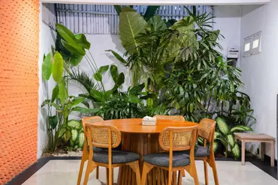 a wooden table and chairs in a room with plants at Massive 3 bedroom villa in heart of Seminyak in Seminyak